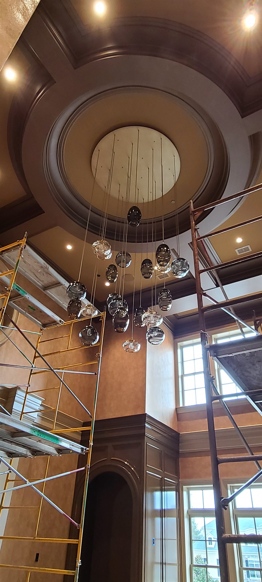 A coffered rotunda ceiling with a bubble-glass chandelier suspended below tall windows